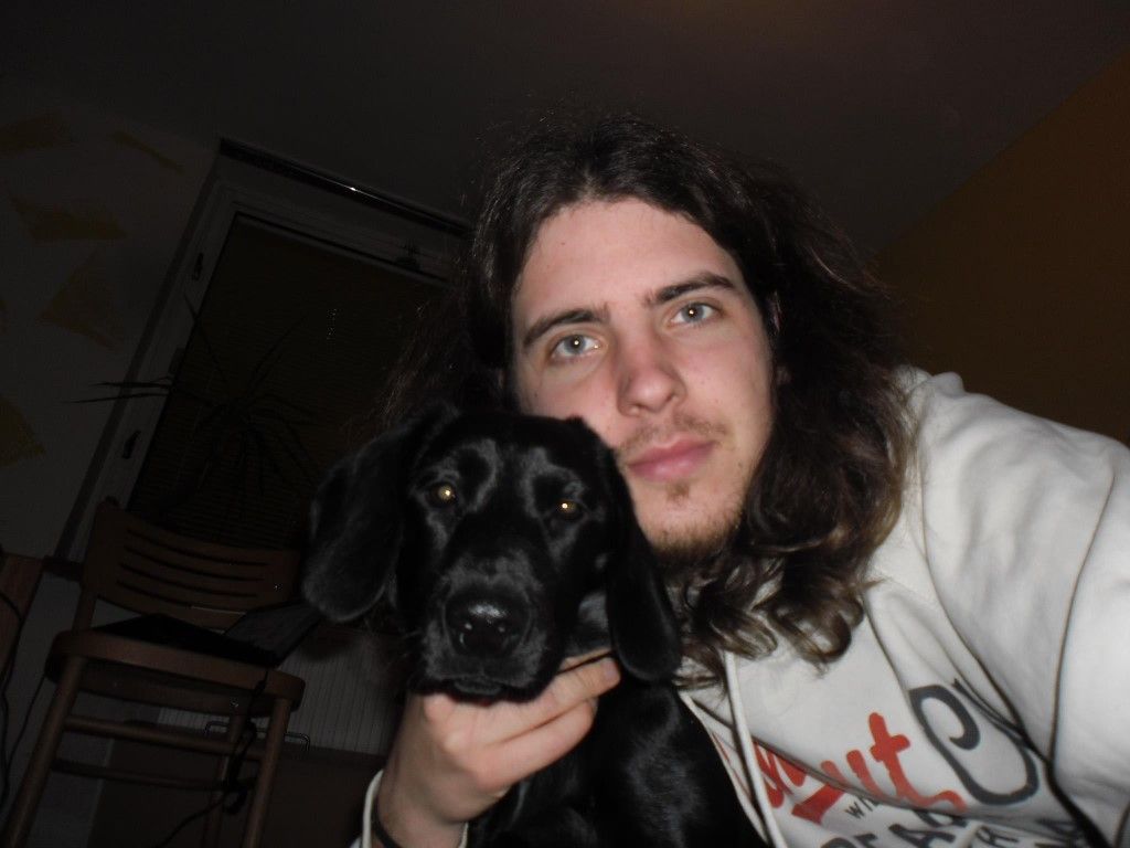 a man pictured with a black dog