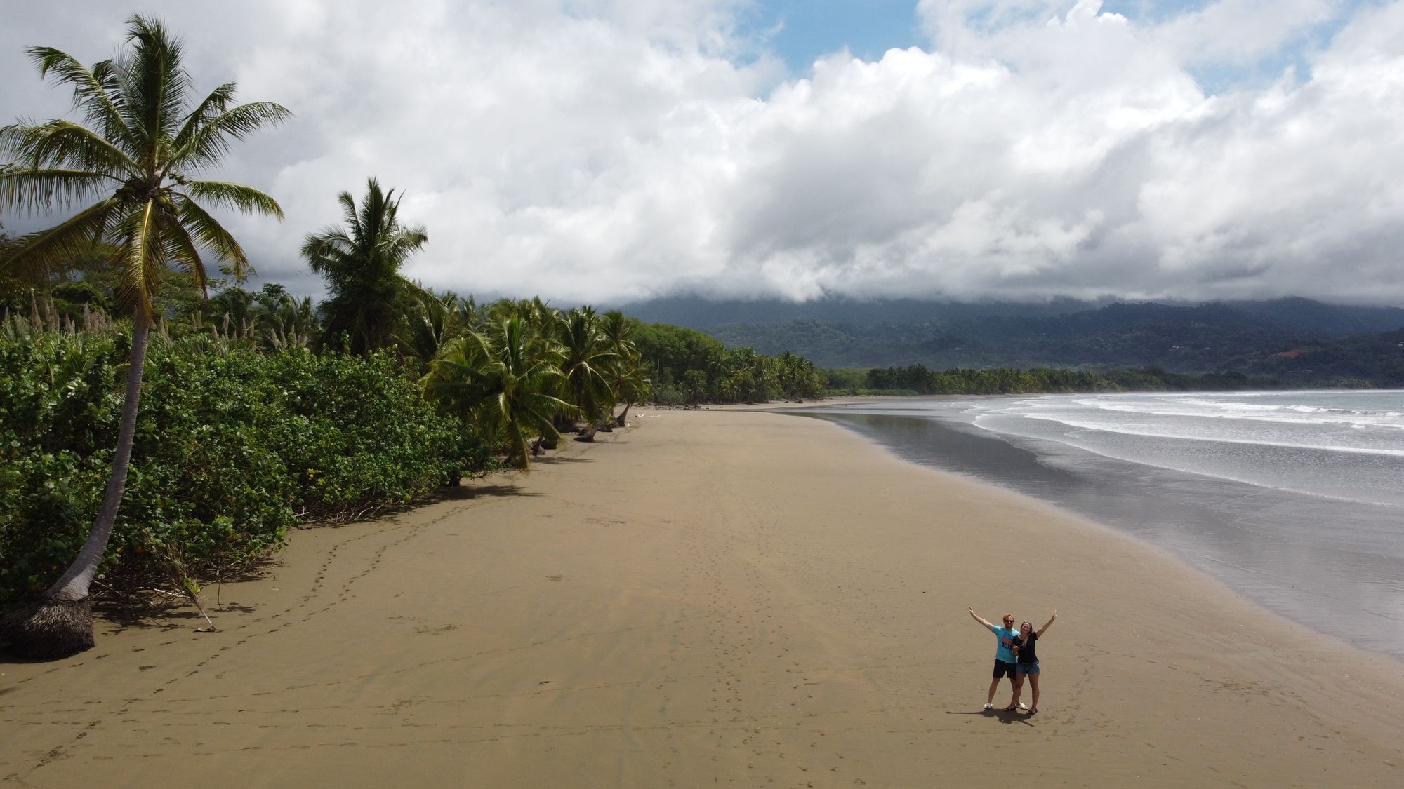 Drone shot of a two people on a beach.