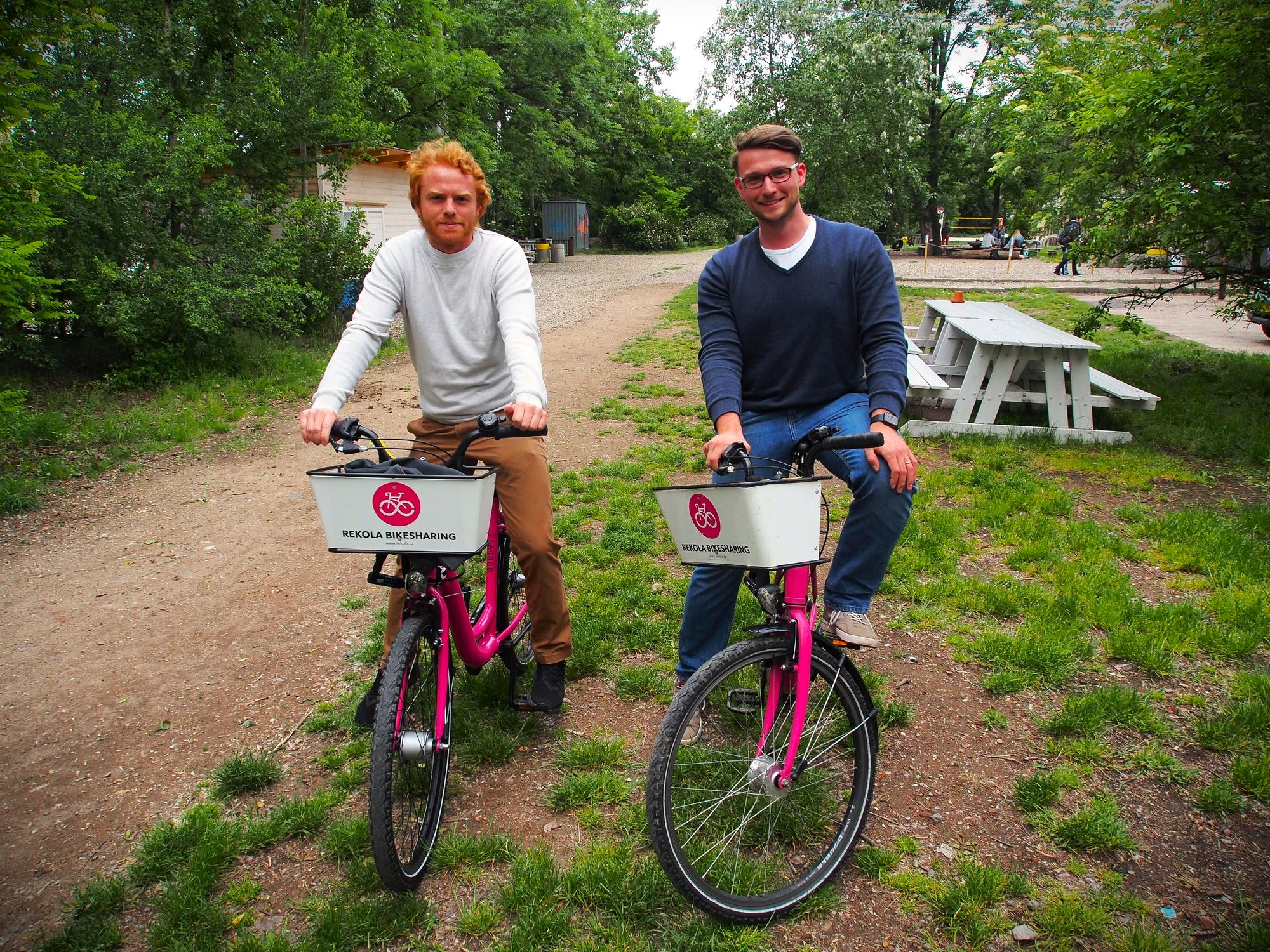 Two apifiers taking picture on pink bikes for rent.