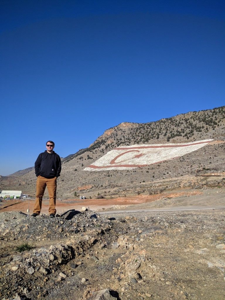 A person standing on a mountain range with no vegetation.