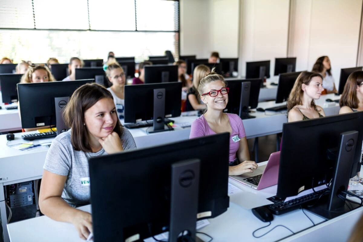 women sitting behind computers
