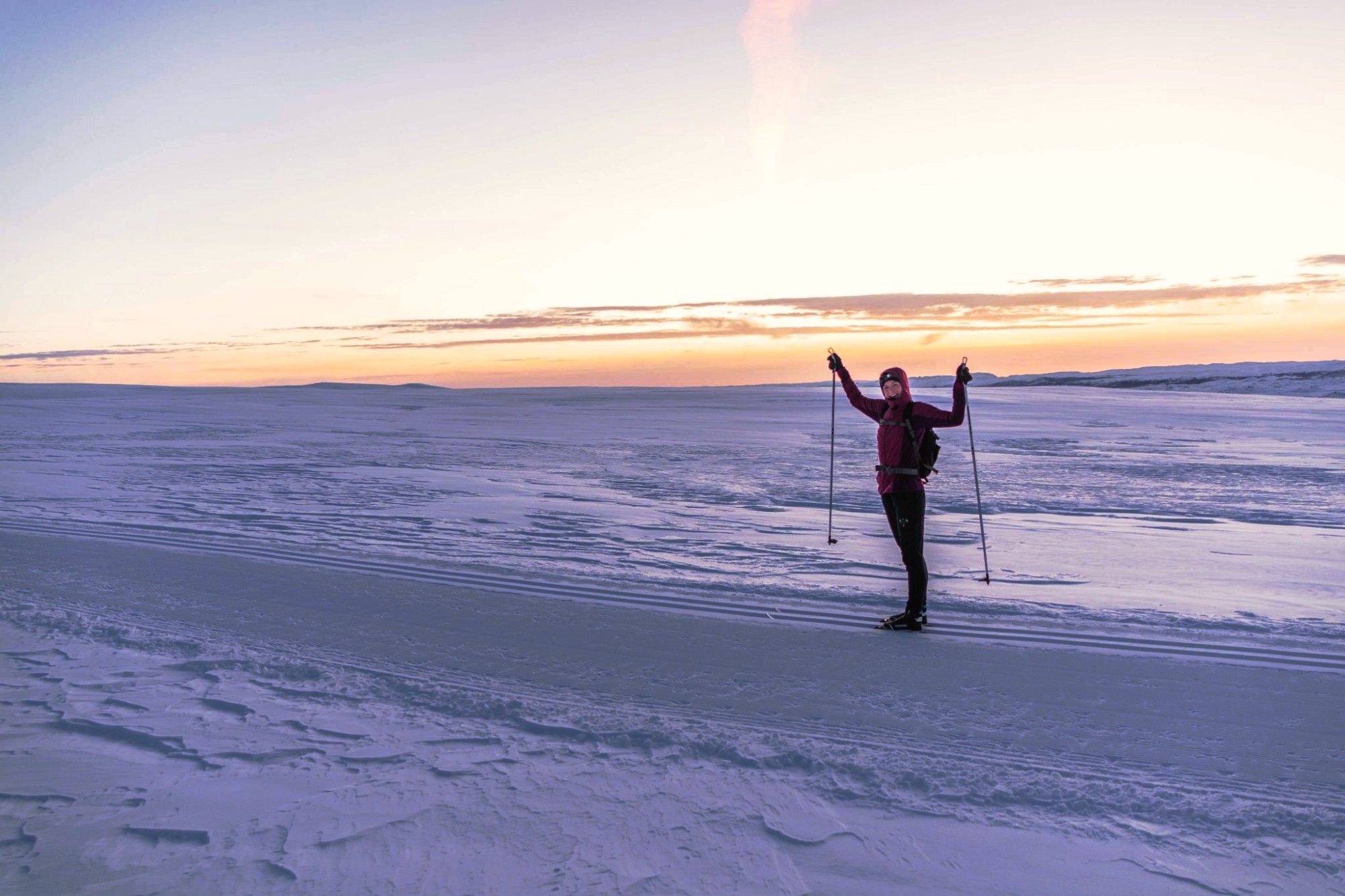 woman waving at the camera on a snowy field